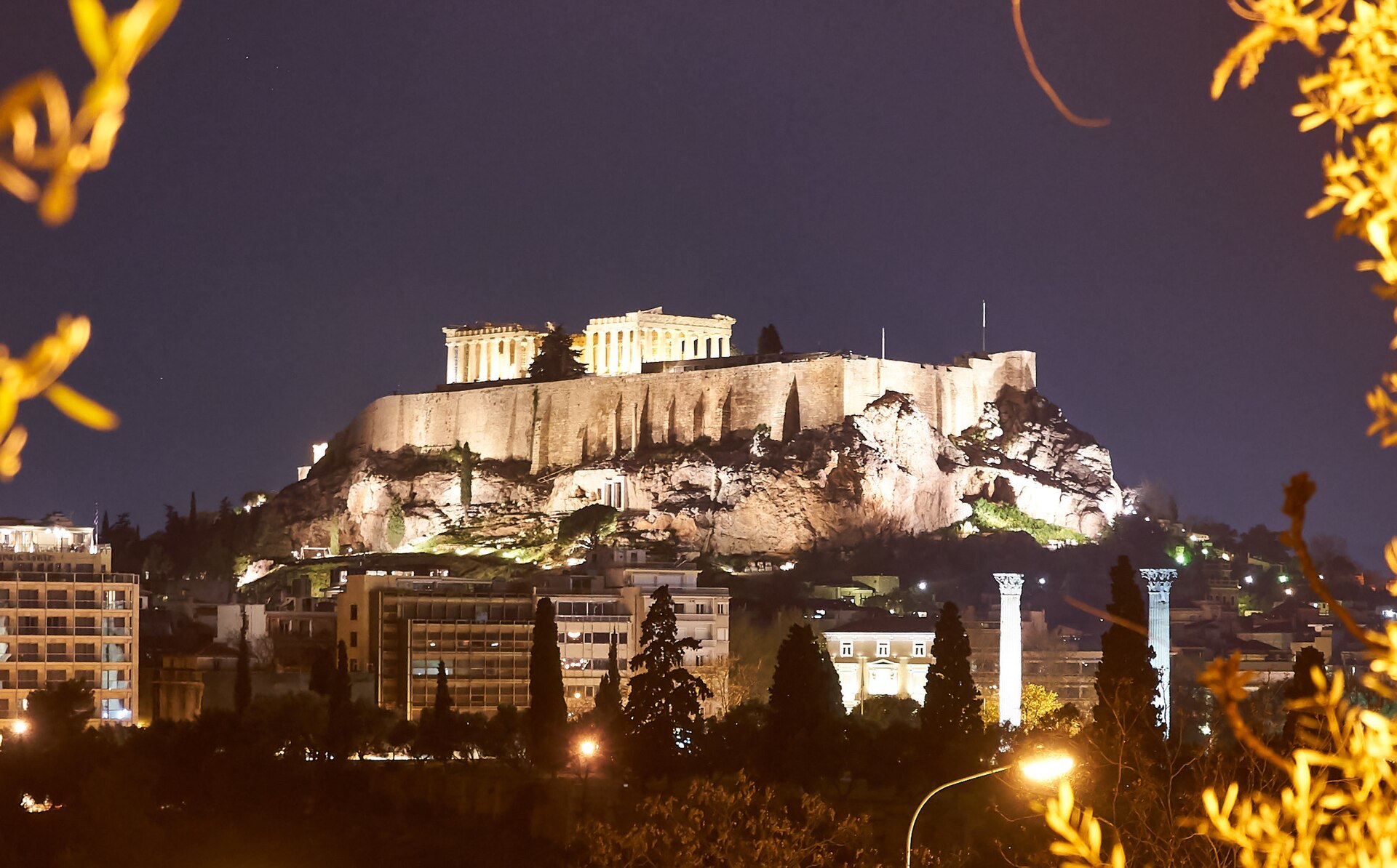 The Acropolis of Athens lit at night above the city.